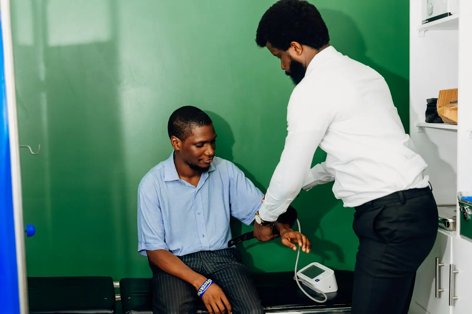 A clinician takes a patient&rsquo;s blood pressure in a consulting room.